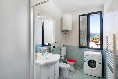 uma casa de banho com um lavatório e uma máquina de lavar roupa em Bussana Mare em Bussana Nuova