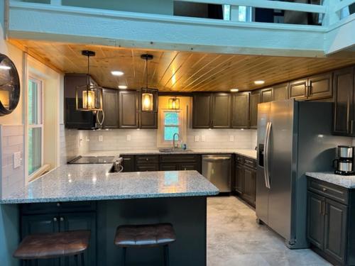 a kitchen with a refrigerator and a counter top at Froggy Goggle Barn in Marathon