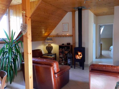 a living room with a couch and a wood stove at Maison de campagne en Alsace 