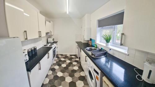 a kitchen with a black and white checkered floor at 2 Bed Spacious Apartment, Sleeps 4, Free Wifi, Free Parking, Amenities Nearby, Good Transport Links Nearby, Contractors and Holidays in Harlow