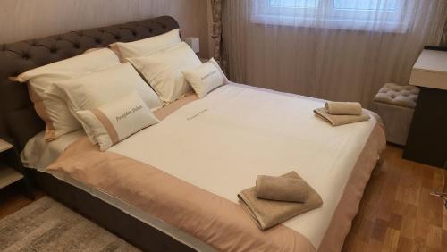a large bed with two pillows on top of it at Apartman Posejdon Deluxe in Vrnjačka Banja