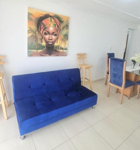 un sofá azul en una sala de estar con una pintura en Cómodo Apto piso 3 en Cartagena de Indias