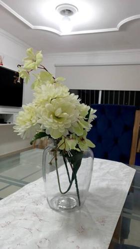 un jarrón lleno de flores blancas en una mesa en Cómodo Apto piso 3 en Cartagena de Indias