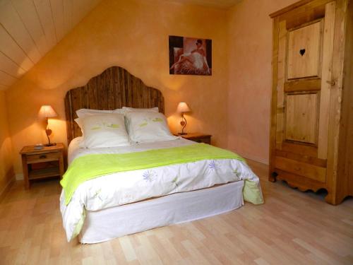 Schlafzimmer mit einem großen Bett mit einem Kopfteil aus Holz in der Unterkunft Maison de campagne en Alsace 