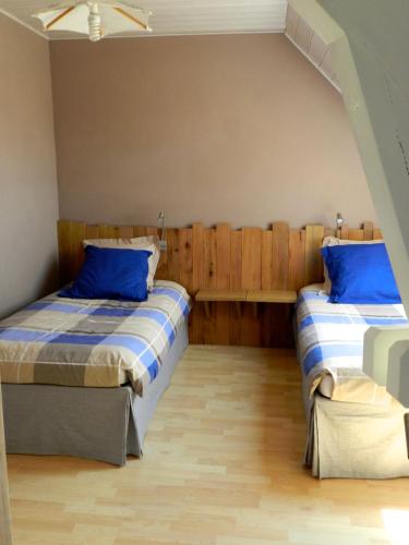 a bedroom with two beds with blue pillows at Maison de campagne en Alsace 