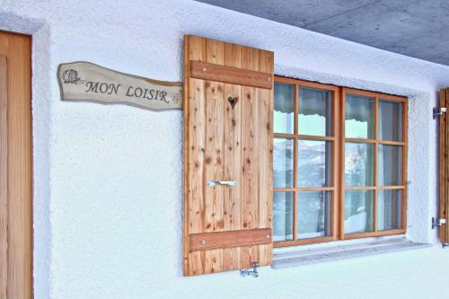 a wooden door on the side of a building with a window at Réveil féerique au cœur des alpes - Vercorin in Vercorin