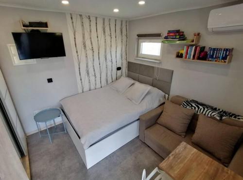 Best Place for You في باتومي: غرفة نوم صغيرة مع سرير وأريكة