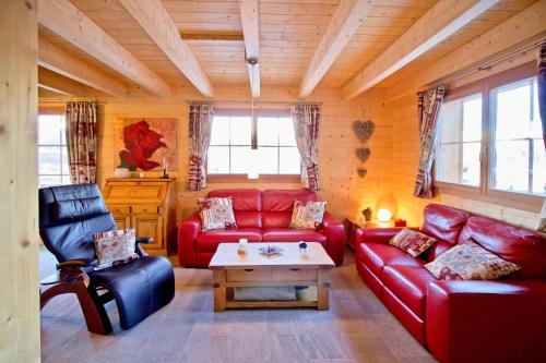 Sala de estar con sofás rojos y mesa de centro en Réveil féerique au cœur des alpes - Vercorin en Vercorin