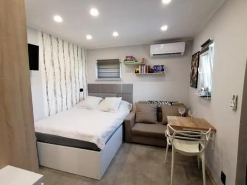 Best Place for You في باتومي: غرفة نوم صغيرة مع سرير وأريكة