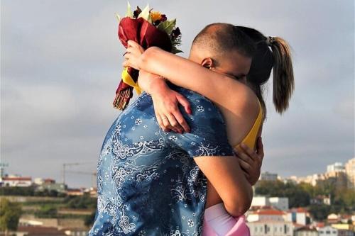 Una mujer está abrazando a una chica con una flor en la espalda en Douro4sailing, en Oporto