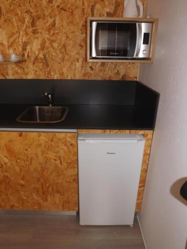 una piccola cucina con forno a microonde e frigorifero di 818 Centro Náutico Bungalows a Vila Real de Santo António