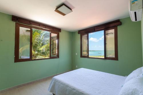 1 dormitorio con 2 ventanas, 1 cama y el océano en Casa Incrível em Barra do Cunhaú por Carpediem en Canguaretama