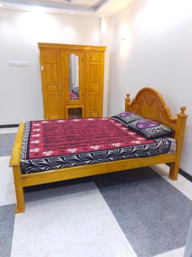 a bedroom with a bed with a wooden bed frame at Sabari Hotel and Restaurant PVT Ltd in Jaffna