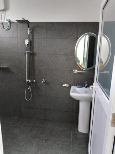 a bathroom with a shower and a sink and a mirror at Sabari Hotel and Restaurant PVT Ltd in Jaffna