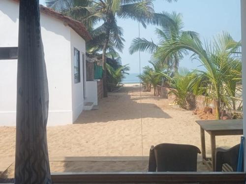 uma vista para uma praia com palmeiras e um edifício em Gajananstay Beach facing Rooms Indians only em Gokarn