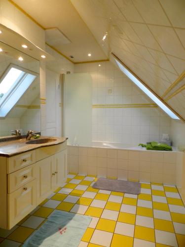 a bathroom with a yellow and white tiled floor at Maison de campagne en Alsace 