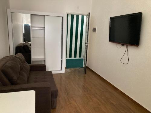 un salon avec un canapé et une télévision à écran plat dans l'établissement Loft no Hotel Quitandinha, à Petrópolis
