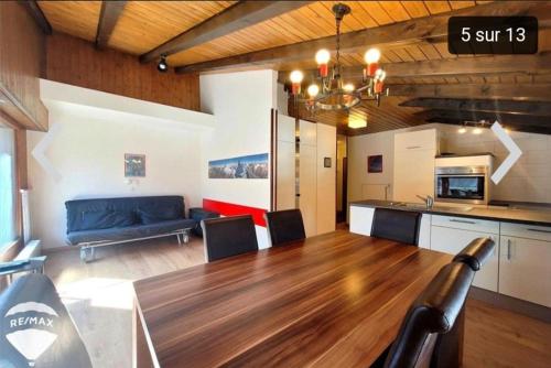 La Remointze في فييسوناز: غرفة معيشة مع طاولة خشبية وأريكة زرقاء