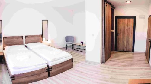 a bedroom with a bed and a chair in it at Penzion Kamence in Liptovský Mikuláš