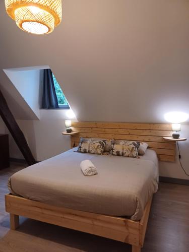 une chambre avec un lit avec une tête de lit en bois dans l'établissement le gîte le CAMÉLIA, à Saint-Aignan