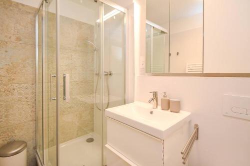 a white bathroom with a sink and a shower at Luxury apartment in city center in Bratislava