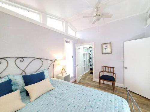 Un dormitorio con una gran cama azul con ventilador de techo. en Large beautiful Magnolia in the sunny Saint Pete., en San Petersburgo