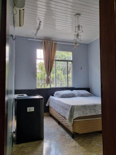 a bedroom with a bed and a window at Suíte completa com SmarTV no centro de Belém in Belém