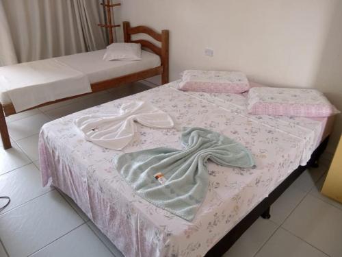 2 camas en una habitación con sábanas rosas y blancas en Pousada Sitio Paraíso en Cabo de Santo Agostinho
