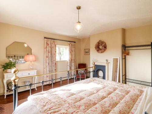 um quarto com uma cama e um espelho em Bluebell Cottage em Rugeley