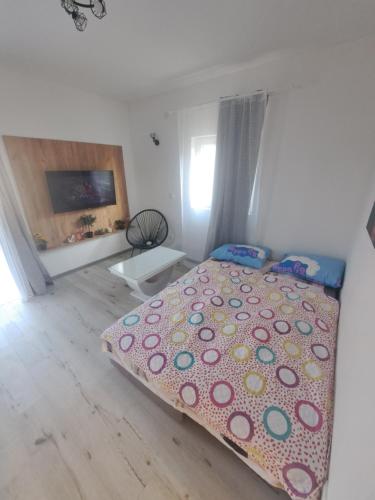 a bedroom with a bed with a polka dot blanket at Apartment West Stara Pazova in Stara Pazova