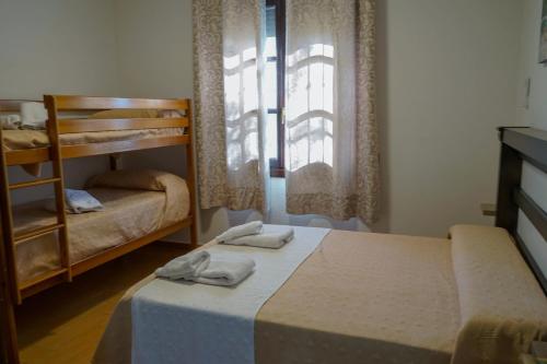 een slaapkamer met 2 stapelbedden en een raam bij La Masía casa rural junto al río in Almedinilla