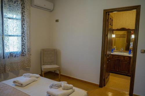 Cette chambre comprend un lit, un lavabo et un miroir. dans l'établissement La Masía casa rural junto al río, à Almedinilla
