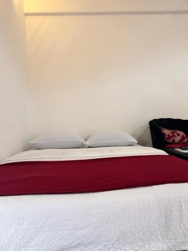 a bed with red and white sheets and pillows at Apartmani Andric in Trebinje