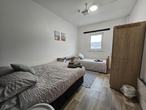 a bedroom with two beds and a sliding door at Neon 160 in Swansea