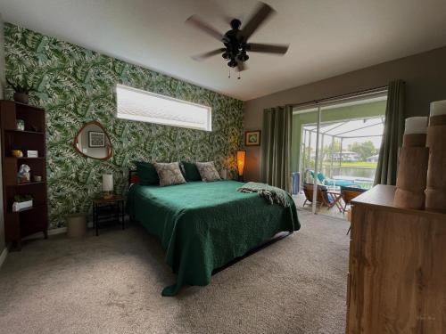 a bedroom with a green bed with a ceiling fan at Its A Dream Family Vacation Rental - Minutes from Disney in Kissimmee