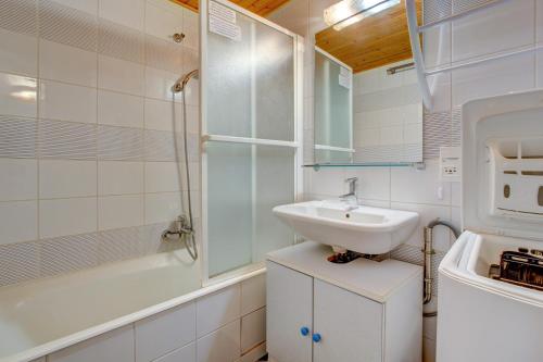 une salle de bain blanche avec un lavabo et une douche dans l'établissement TACOUNET A14, à Morzine