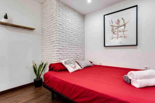 ein rotes Bett in einem Zimmer mit Ziegelwand in der Unterkunft Gelish in Sugdidi