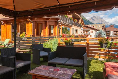 eine Terrasse mit Stühlen und Tischen sowie ein Gebäude in der Unterkunft Hotel La Val in Valdidentro