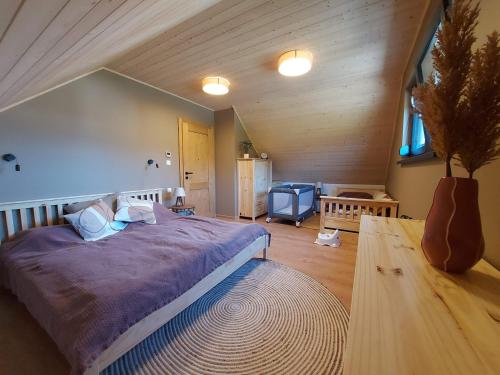 um quarto com uma cama grande num sótão em CHALUPY TRI GROŠE VLAŠKY em Bešeňová