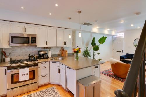 a kitchen with white cabinets and a stove top oven at 2 Mi to National Mall Stunning Townhome with Patio! in Washington, D.C.