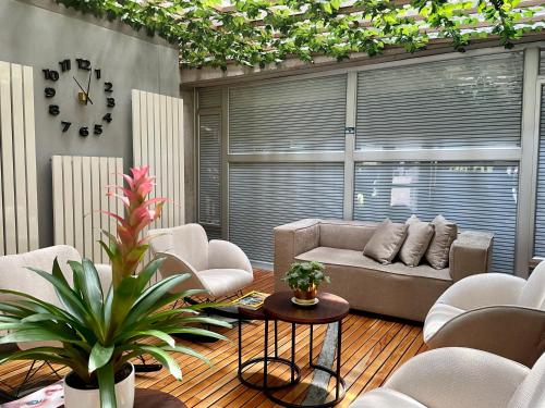 a living room with a couch and chairs and a clock at Hotel 5 Elementos Corferias by HBP in Bogotá