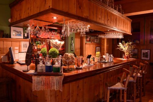 a bar in a restaurant with wooden walls and chairs at Correntoso Lake & River Hotel in Villa La Angostura