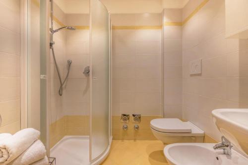 uma casa de banho com um chuveiro, um WC e um lavatório. em Buffaure a parte em Pozza di Fassa