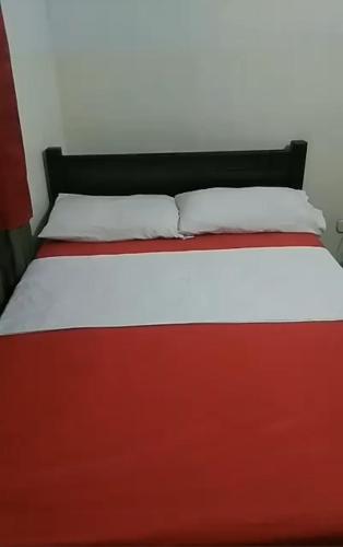 a red and white bed with two pillows on it at Estacion plaza in Ibagué