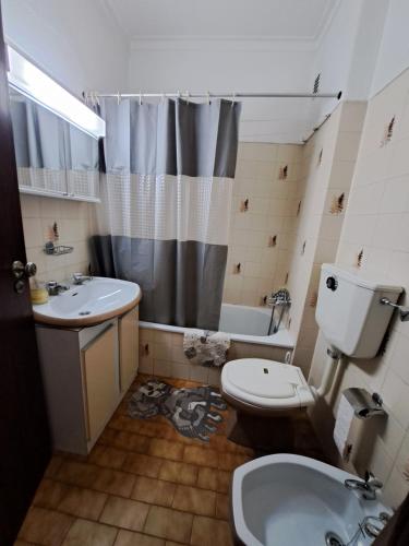 a bathroom with a toilet and a sink and a shower at Apart Praia da Costa da Caparica in Costa da Caparica
