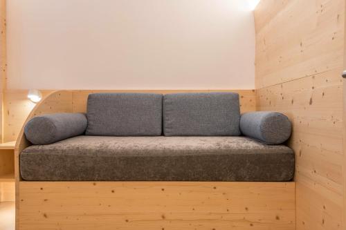 a gray couch sitting in a wooden room at Buffaure a parte in Pozza di Fassa