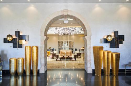 a lobby with an archway and a dining room at Lady Stern Jerusalem Hotel in Jerusalem