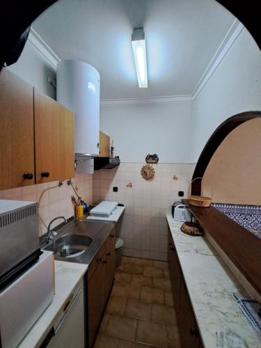 a kitchen with a sink and a counter top at Apart Praia da Costa da Caparica in Costa da Caparica