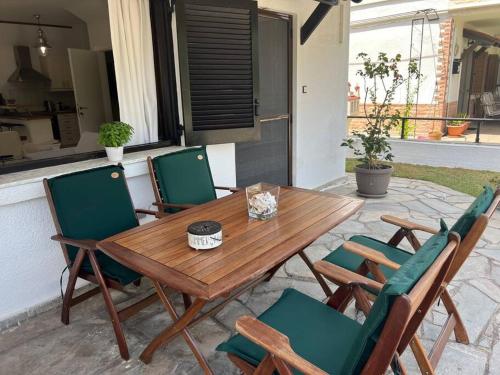 a wooden table and chairs on a patio at Salty Breeze #Hosted by DoorMat in Neoi Epivates