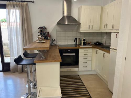 a kitchen with white cabinets and a stove top oven at Salty Breeze #Hosted by DoorMat in Neoi Epivates